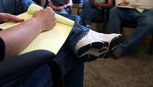 Group therapy, person taking notes