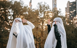 Two people wearing sheet ghost costumes