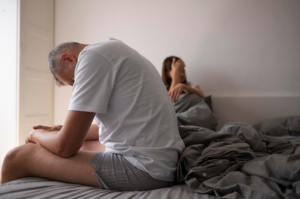 A sad couple in bed before getting sex addiction treatment in Idaho