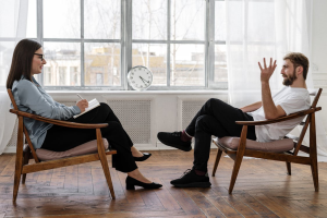 A man sitting across from a therapist during his intake session
