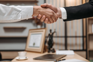 A close-up of two individuals shaking hands in a professional setting.