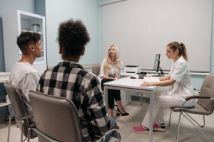 An image of a doctor talking to three people