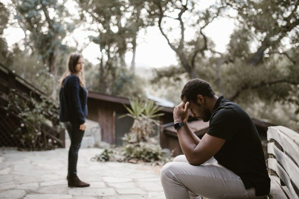 Woman looking toward a stressed man seated beside her.