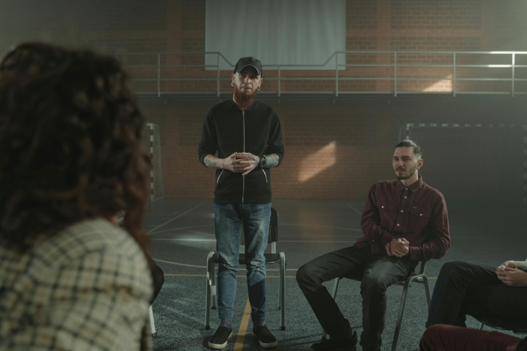 Group of men in an inpatient recovery program discussing responsibility and relapse prevention.