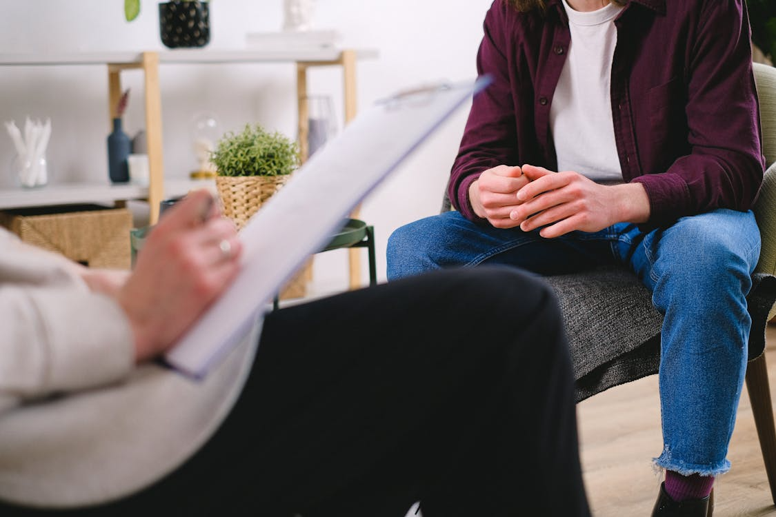 A man in therapy practicing coping skills with a counselor in a quiet session room.