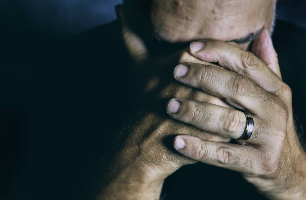 Man covering his face in despair.