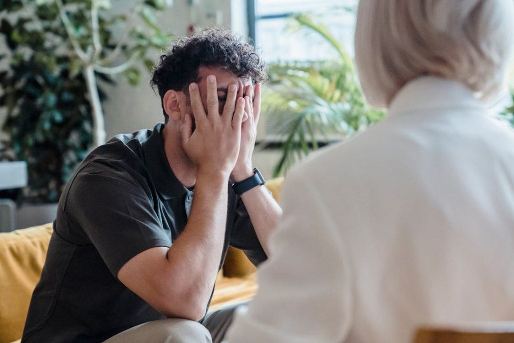 a man hiding his face out of shame