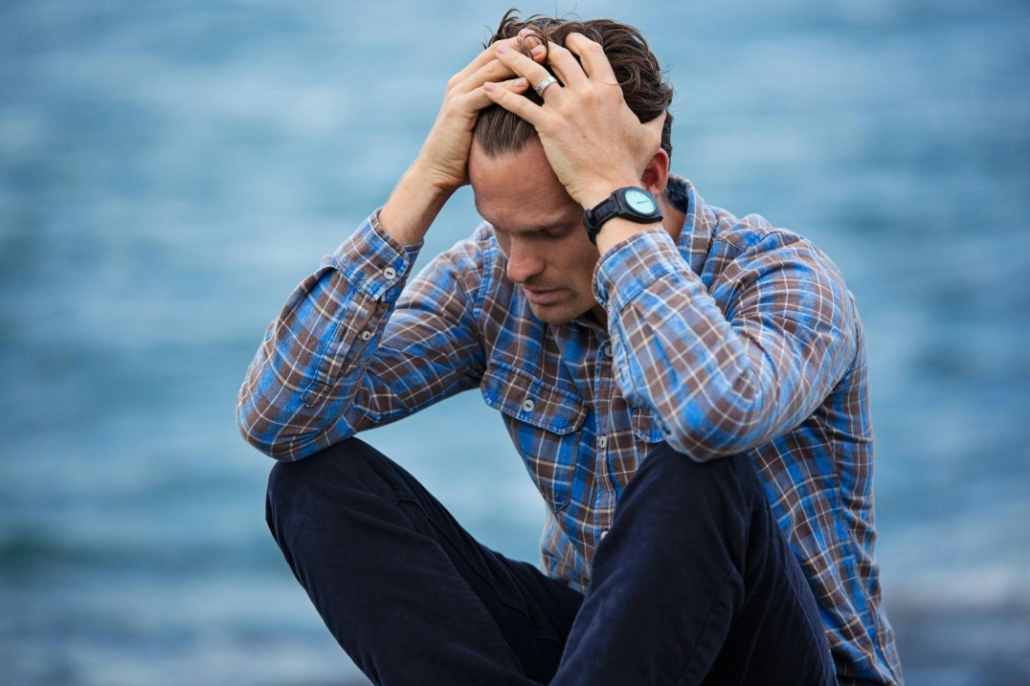 This photo shows a man holding his head.